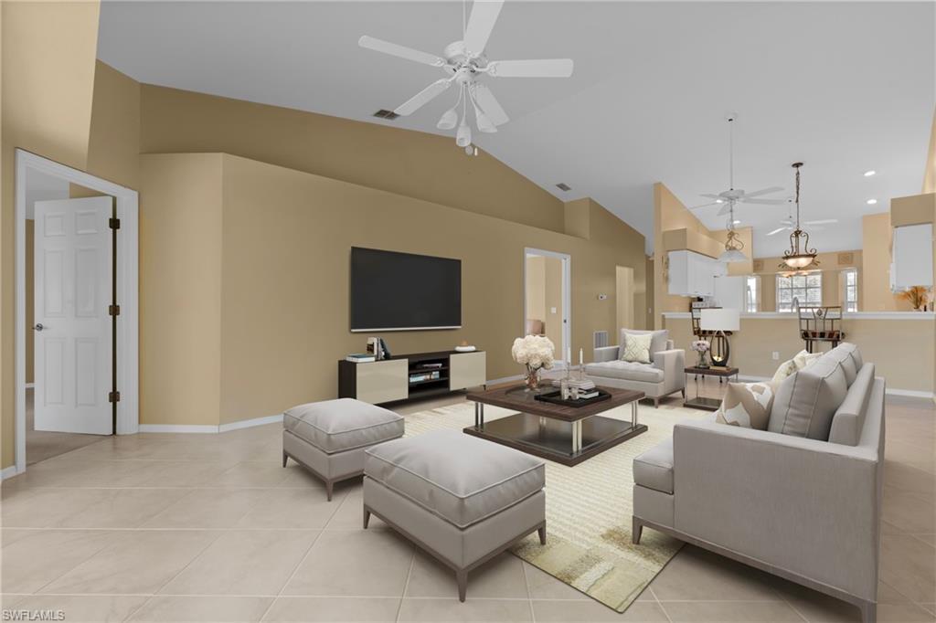 Virtually Staged - Spacious living area featuring vaulted ceilings, light-toned tile flooring, and multiple ceiling fans