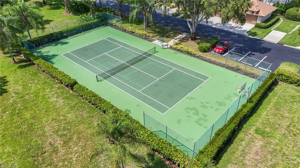 Full-sized tennis court with green surface and white court lines