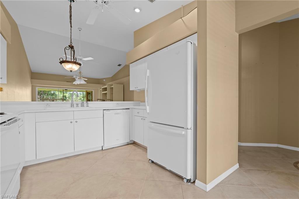 Kitchen featuring white cabinetry, a refrigerator, and a dishwasher
