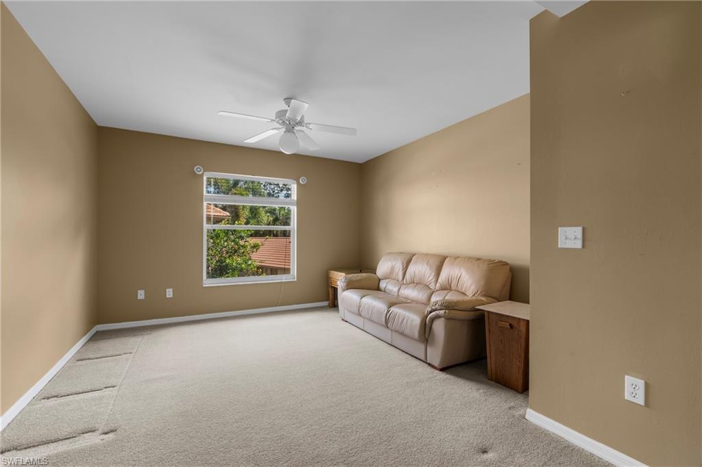 Carpeted room with a ceiling fan, a window, and neutral wall tones
