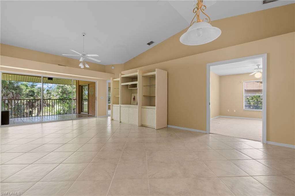 Expansive living area with tile flooring and a vaulted ceiling