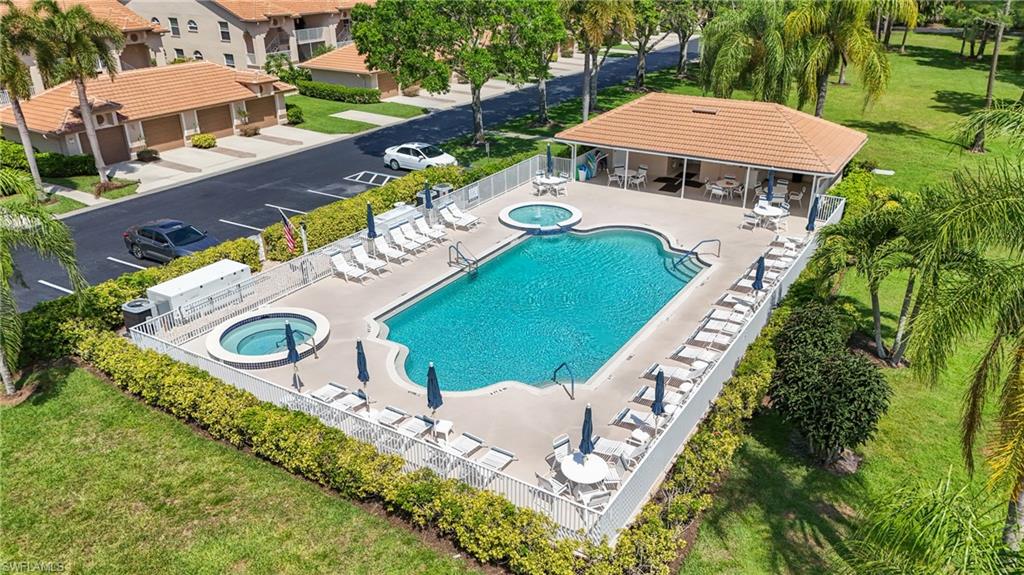 Resort-style pool area featuring a freeform swimming pool, two integrated spas, and an adjacent covered cabana