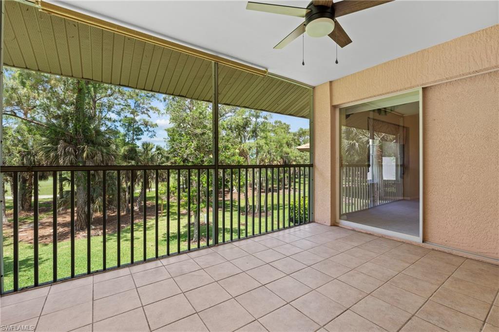 Screened outdoor living area featuring a tile floor, ceiling fan, and sliding glass door