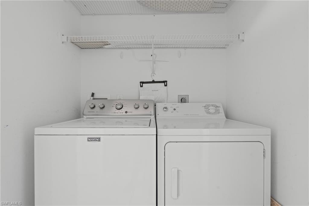 Dedicated laundry area featuring a white top-load washing machine and front-load dryer