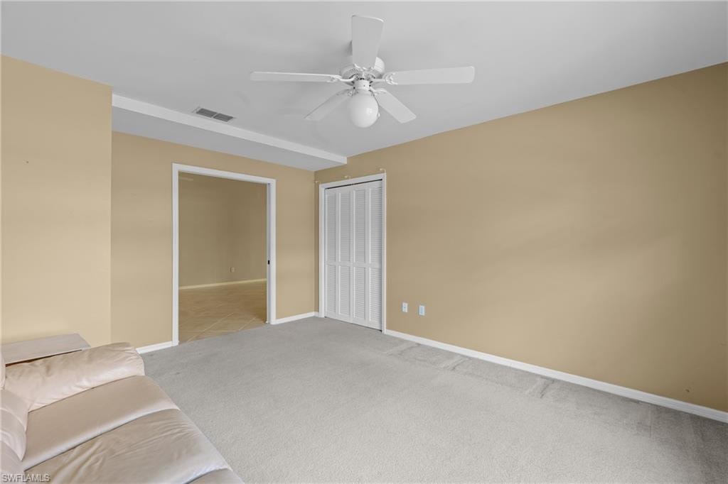 Spacious interior room featuring light beige walls and light gray carpet flooring