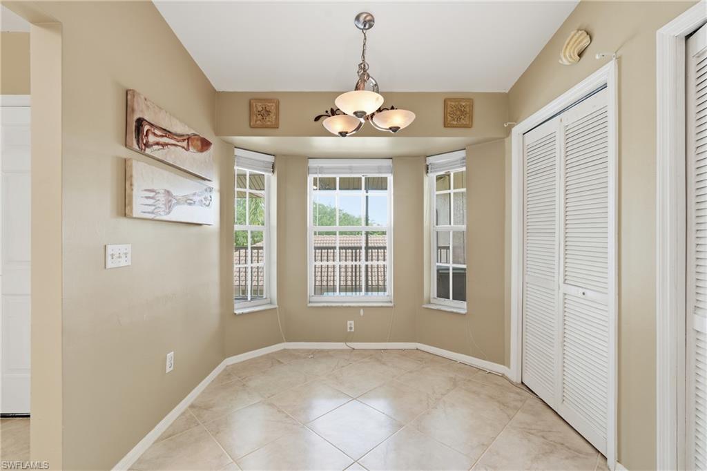 Unfurnished dining area featuring a chandelier and light tile patterned floors