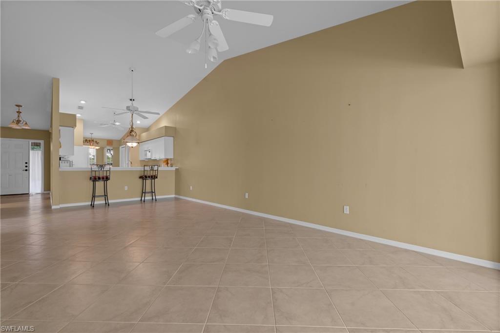 Spacious interior with tile flooring and vaulted ceilings