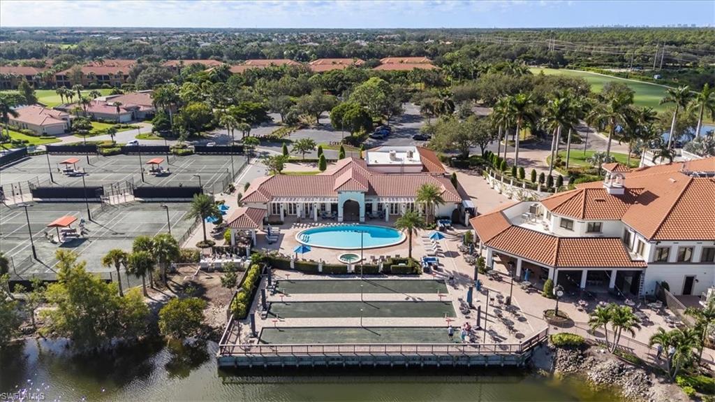 Drone / aerial view of a nearby body of water and a pool