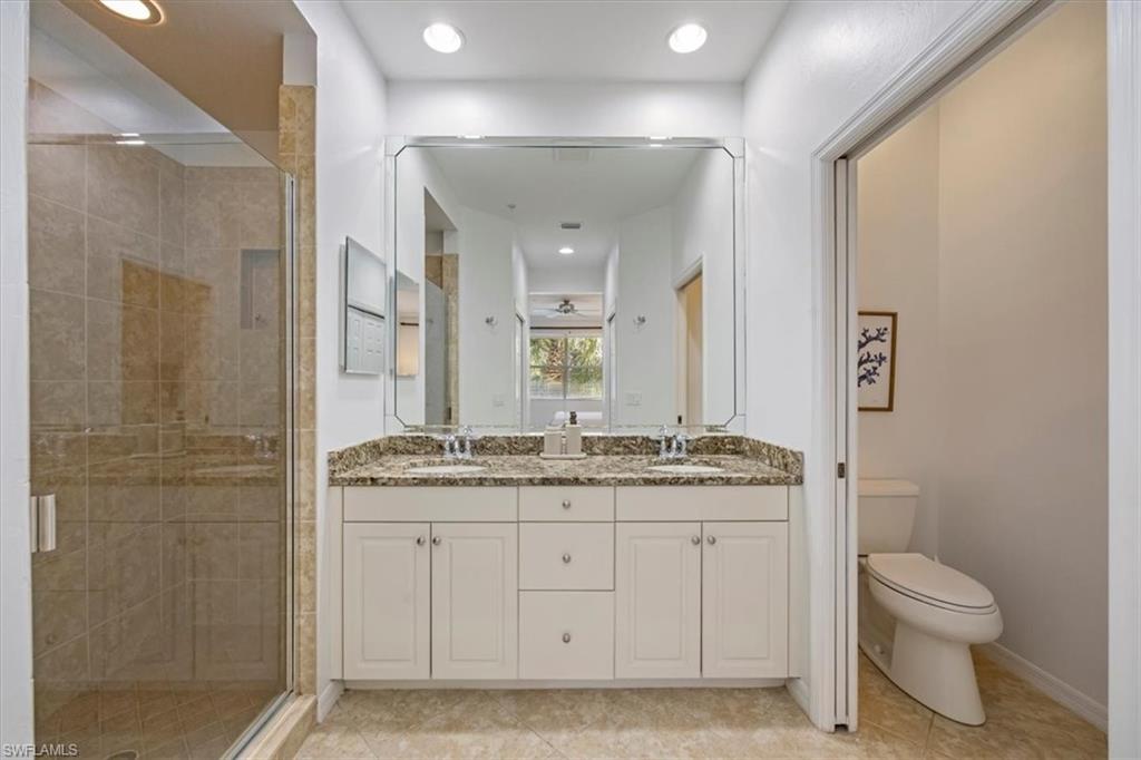 Bathroom with double vanity, a stall shower, recessed lighting, and light tile patterned floors