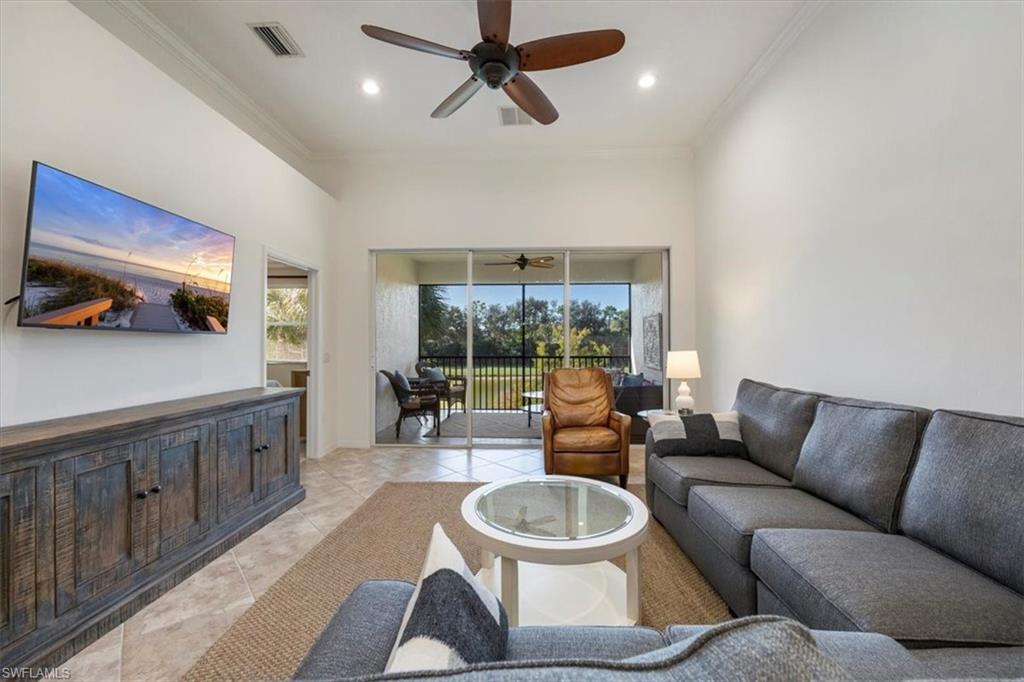 Living area featuring ornamental molding, recessed lighting, a sunroom, light tile patterned flooring, and a ceiling fan