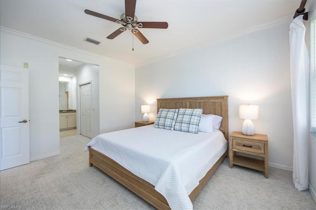 Carpeted bedroom featuring crown molding and ceiling fan and King size bed