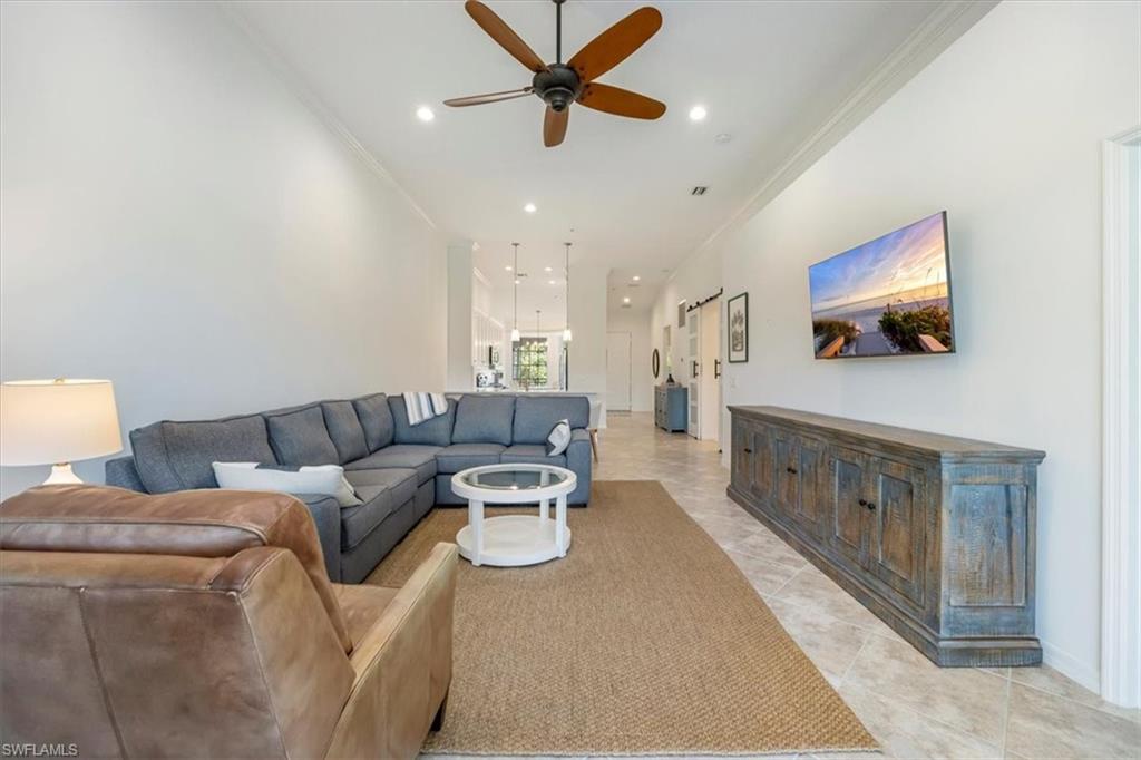 Living room with ornamental molding, recessed lighting, a ceiling fan, and light tile patterned floors