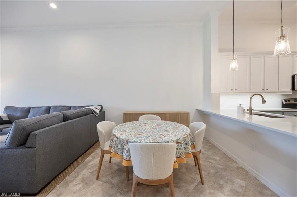 Dining space with ornamental molding and recessed lighting
