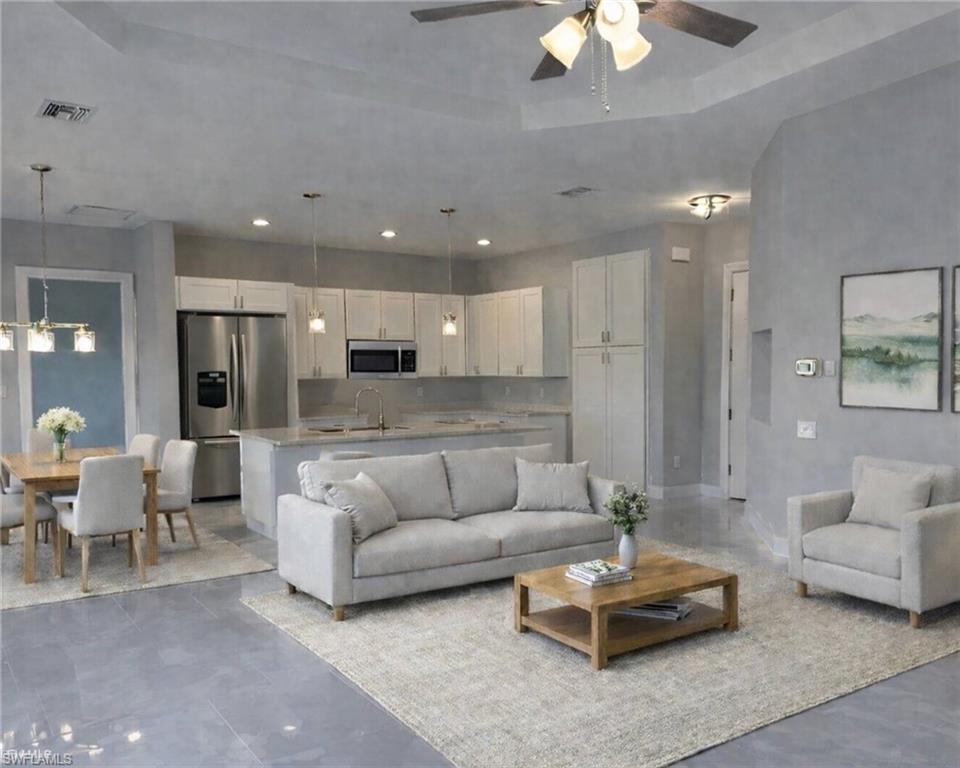Living area featuring ceiling fan and a tray ceiling