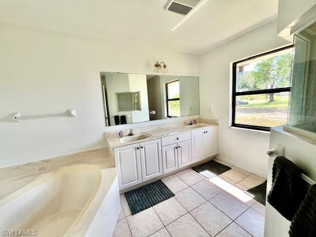 Bathroom featuring light tile patterned floors, double vanity, and a garden tub