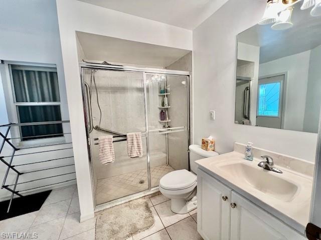 Full bathroom with vanity, light tile patterned floors, and a stall shower