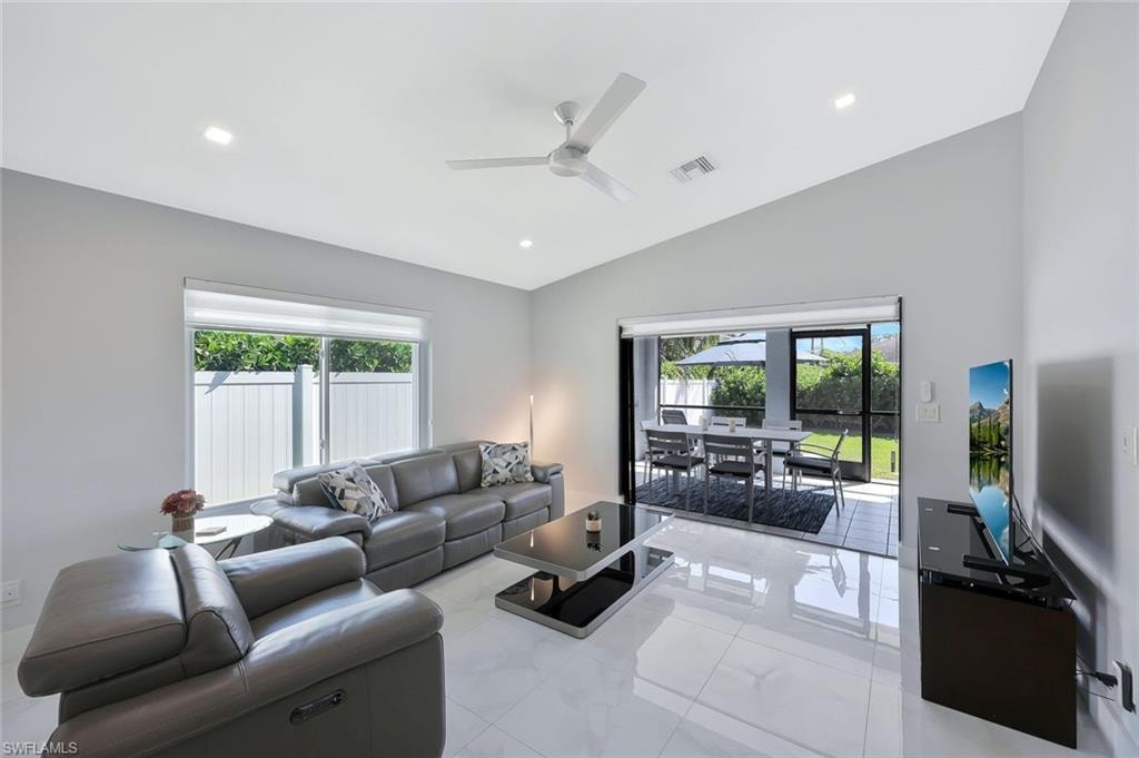 Living area featuring recessed lighting, plenty of natural light, lofted ceiling, ceiling fan, and light tile patterned flooring