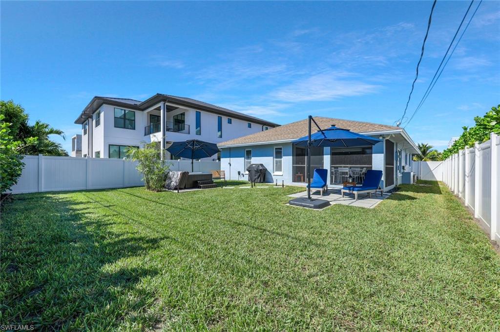 Rear view of house featuring a fenced backyard, a patio area, and an outdoor living space
