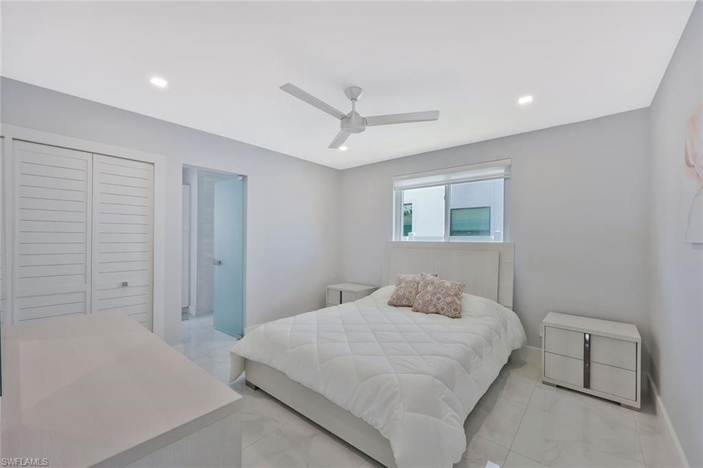 Bedroom featuring ceiling fan, recessed lighting, a closet, and light marble finish flooring