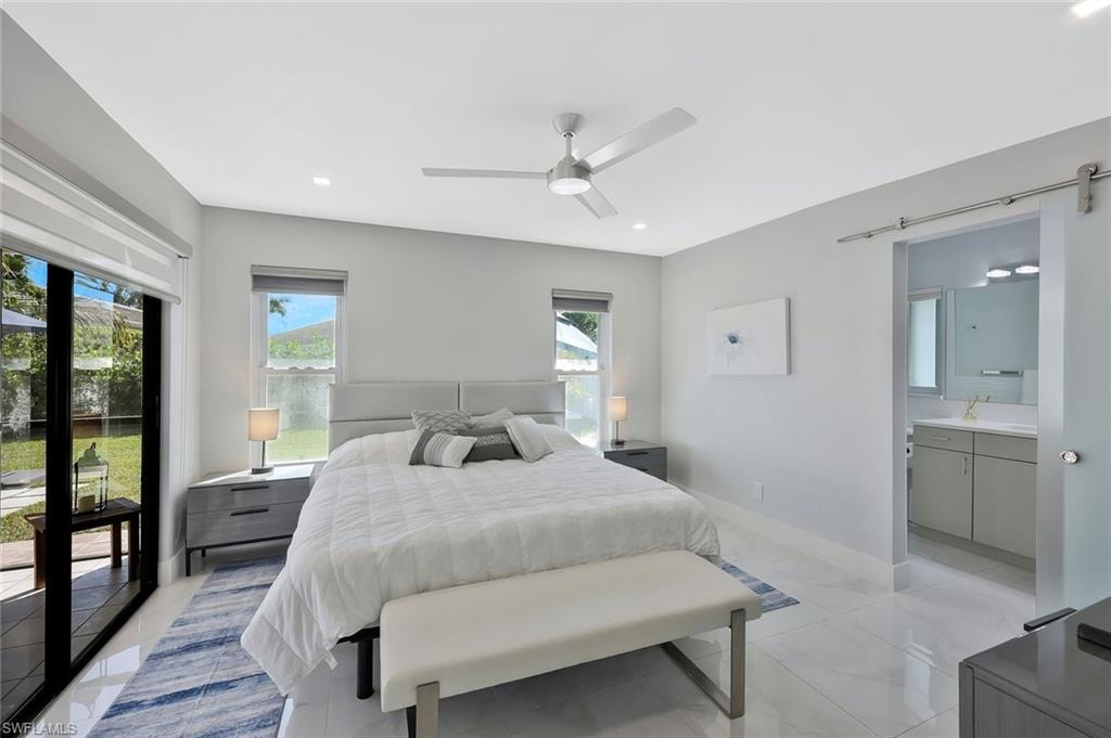 Bedroom with a barn door, ceiling fan, recessed lighting, and light tile patterned floors