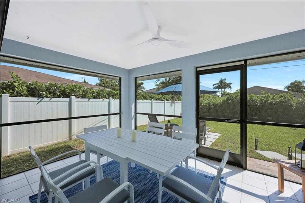 Sunroom with a ceiling fan and outdoor dining area