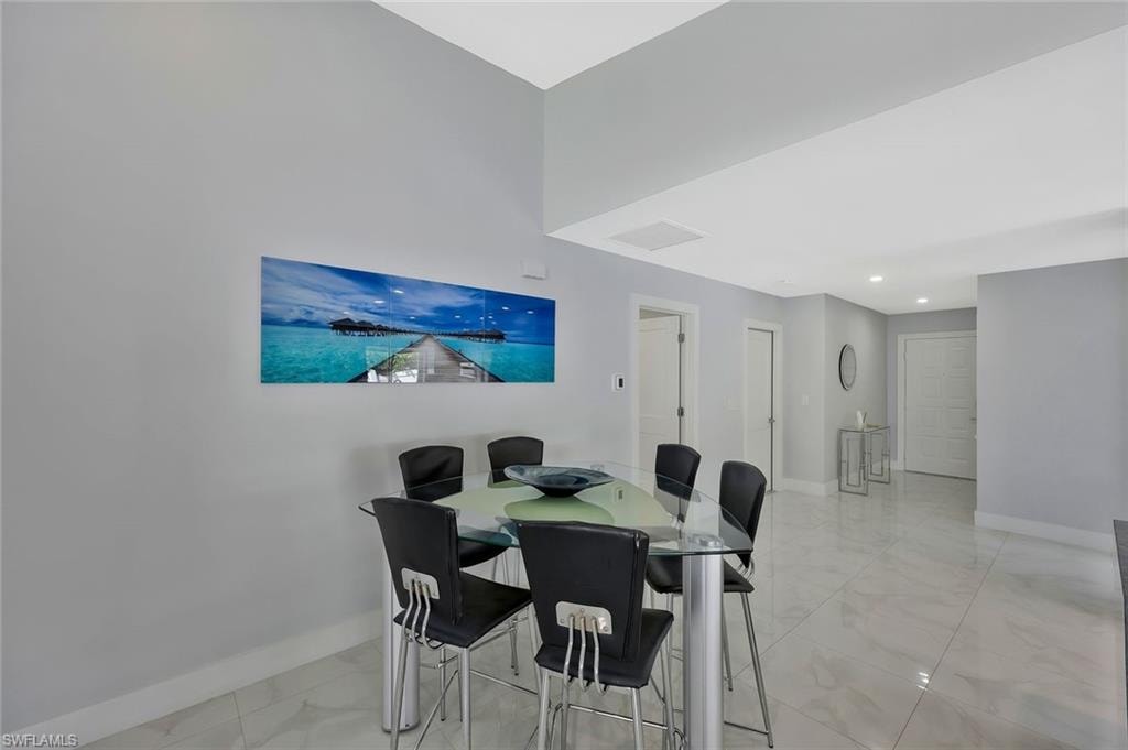 Dining space featuring light marble finish flooring and recessed lighting