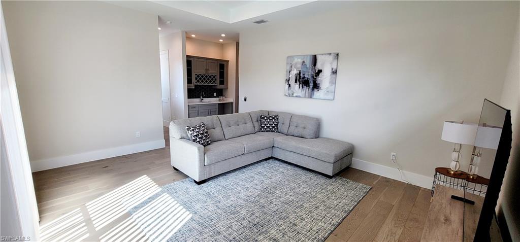 Upstairs Living area with light wood finished floors, recessed lighting, and bar