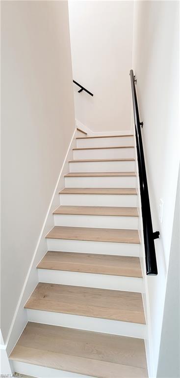 Staircase featuring wood finished floors