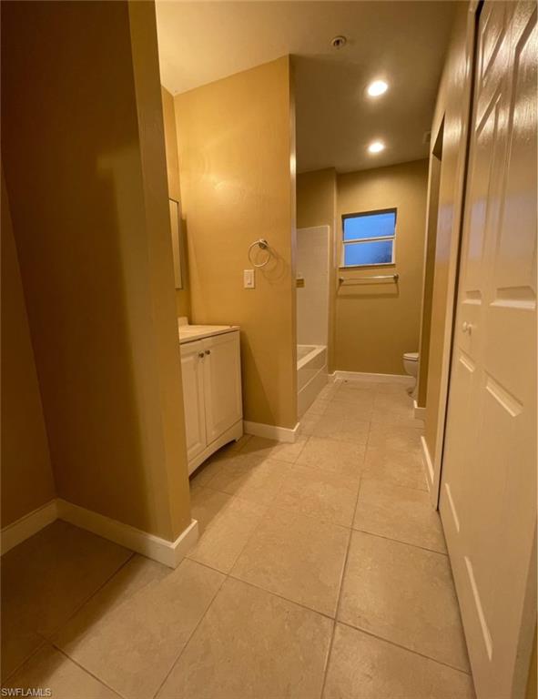 Bathroom featuring vanity, light tile patterned floors, shower / washtub combination, and recessed lighting