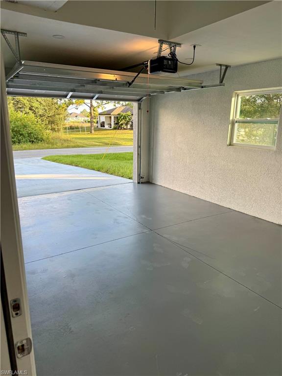 Garage featuring a textured wall and a garage door opener