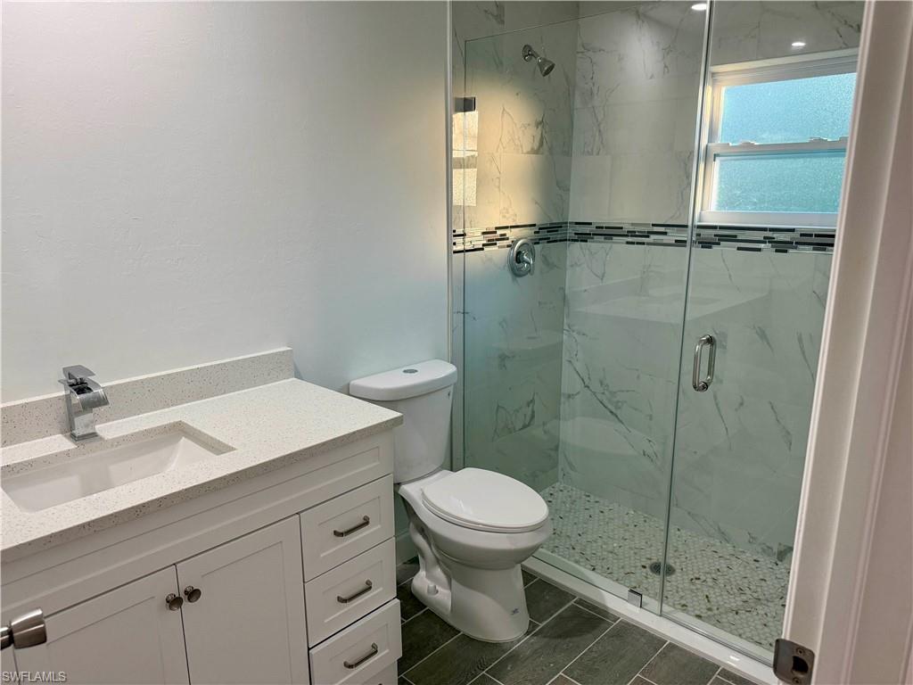 Full bathroom with vanity and a marble finish shower