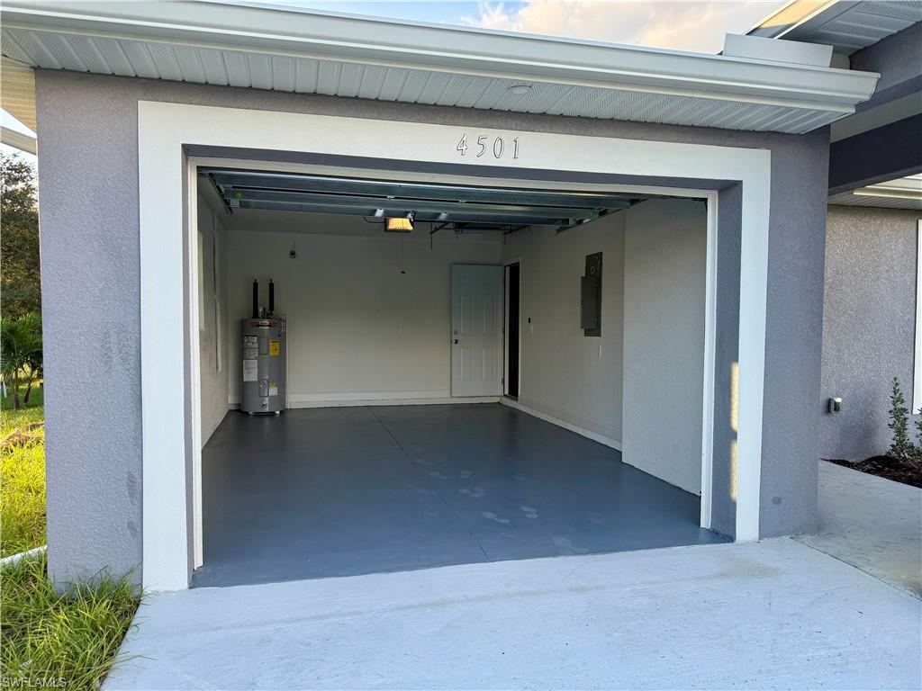 Garage featuring water heater and electric panel