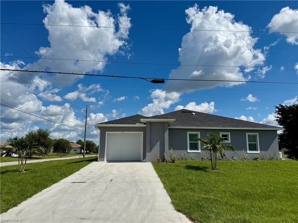 Ranch-style house featuring a front yard, stucco siding, a garage, and concrete driveway