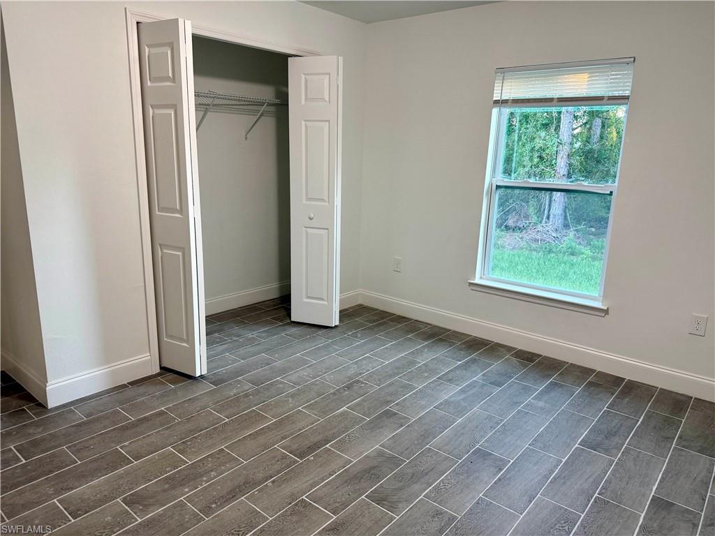 Unfurnished bedroom featuring a closet and wood tiled floors
