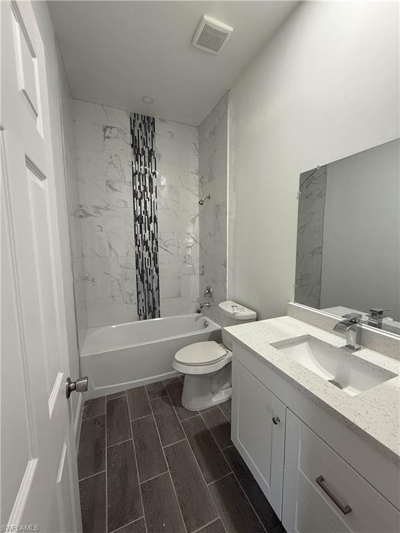 Bathroom with tub / shower combination, vanity, and wood tiled floors