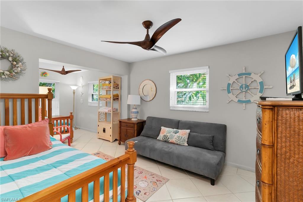 Bedroom with light tile patterned floors and a ceiling fan
