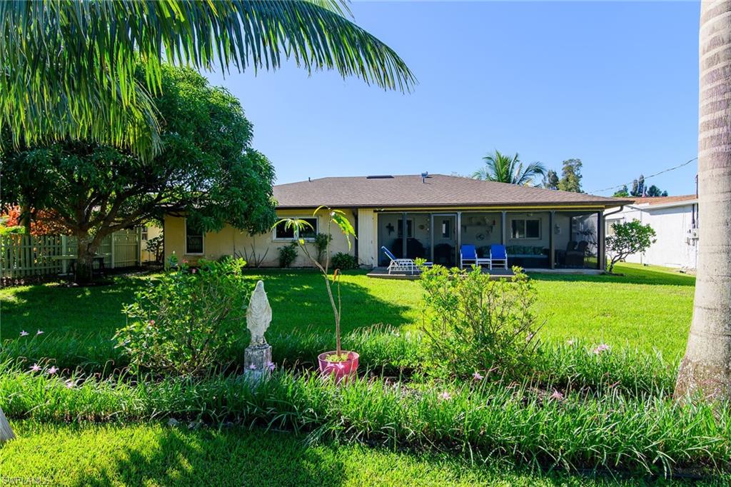 View of front of home with a front lawn, stucco siding, and a sunroom