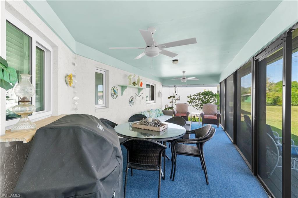 Sunroom featuring outdoor dining area, a ceiling fan, and healthy amount of natural light