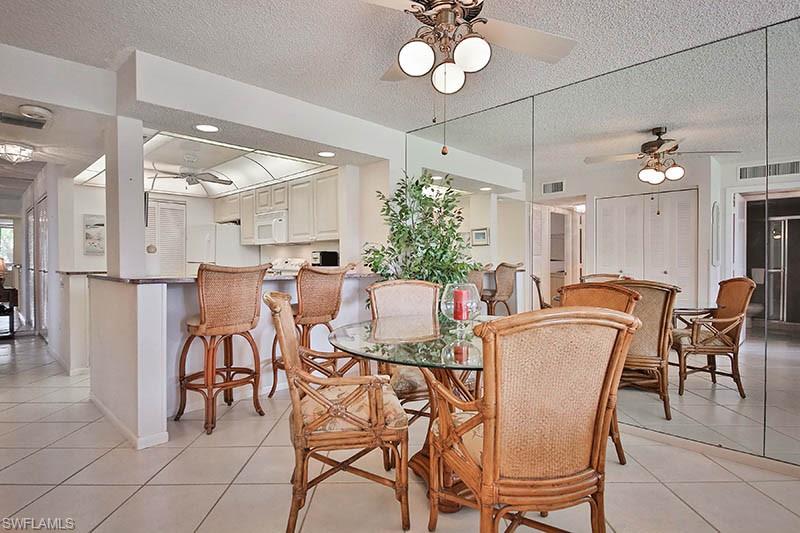Dining room with a ceiling fan, light tile patterned flooring, and a textured ceiling