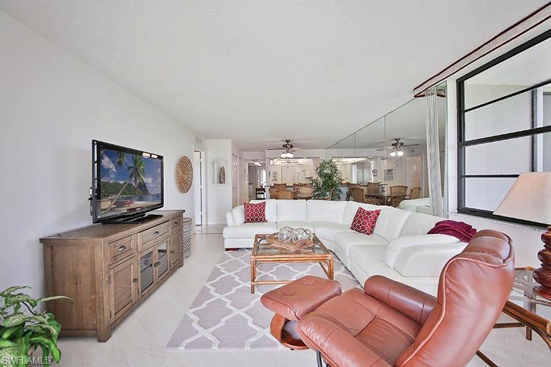 Living area with ceiling fan and light tile patterned flooring