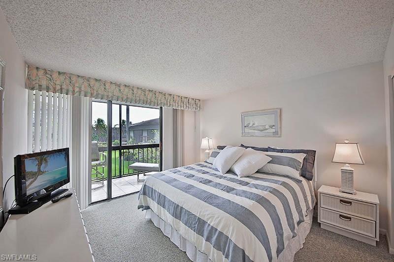 Carpeted bedroom with a textured ceiling and access to exterior