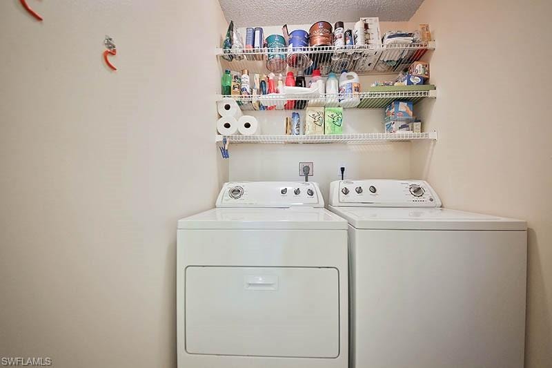 Laundry area with washing machine and clothes dryer and a textured ceiling