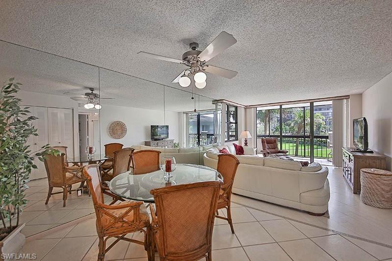 Dining room featuring floor to ceiling windows, a textured ceiling, light tile patterned flooring, and a ceiling fan