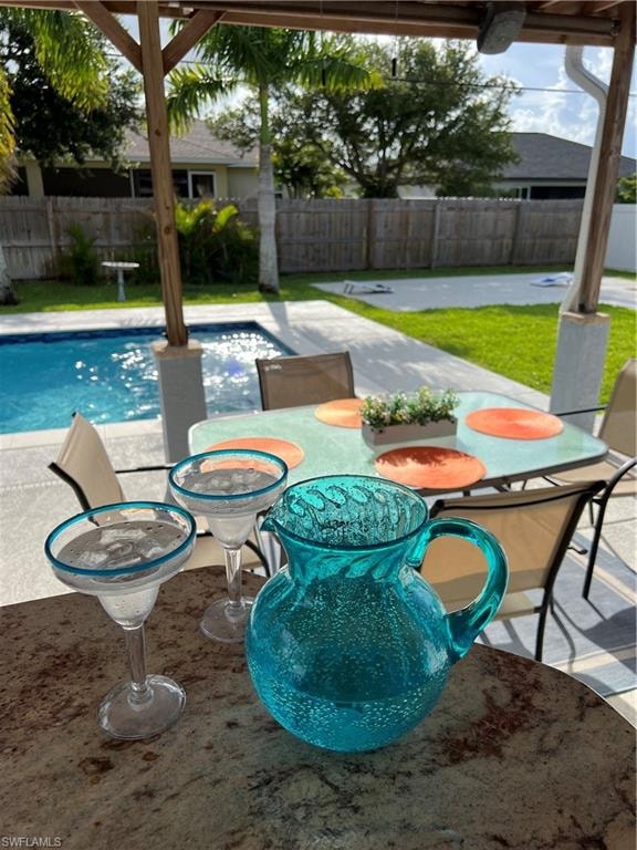 View of swimming pool featuring a fenced backyard, a patio, outdoor dining area, and a water slide