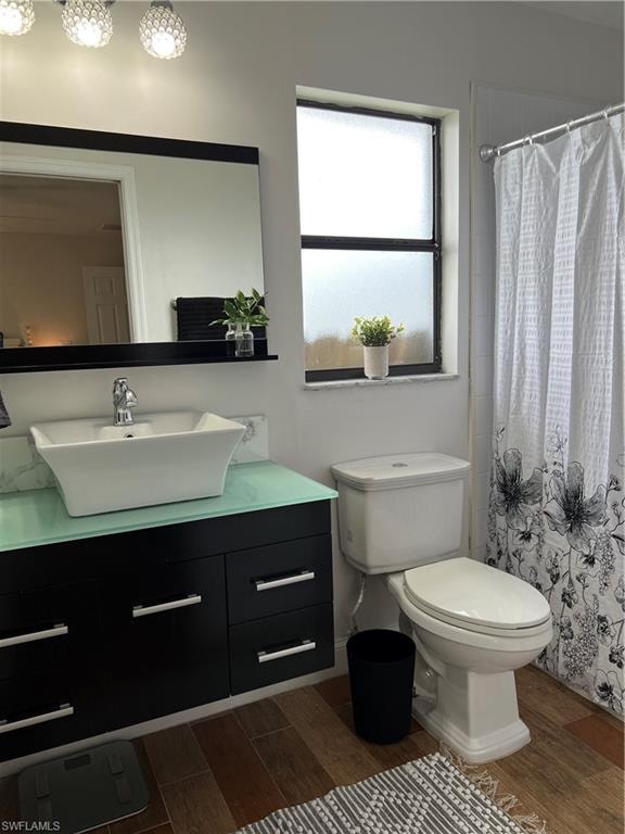 Bathroom with wood tiled floors, vanity, and a shower with shower curtain