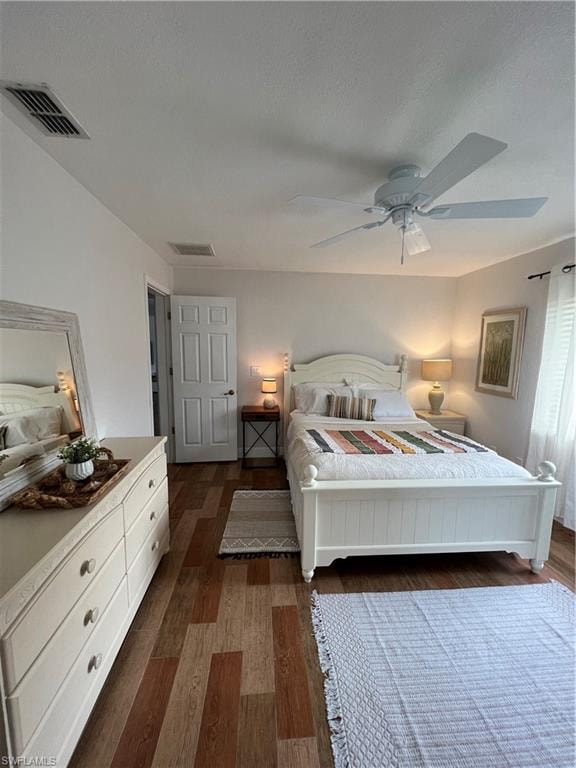 Bedroom featuring dark wood-style floors, a ceiling fan, and a textured ceiling