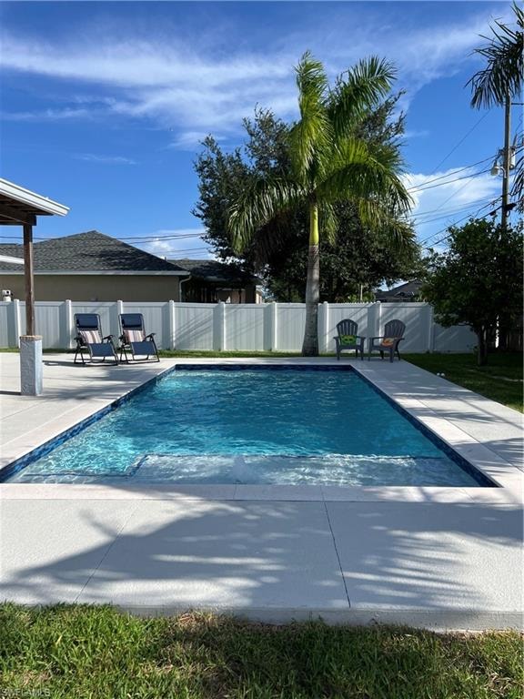 View of swimming pool with a patio area and a fenced backyard