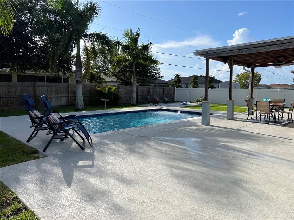 View of pool with a patio, a fenced backyard, and outdoor dining space