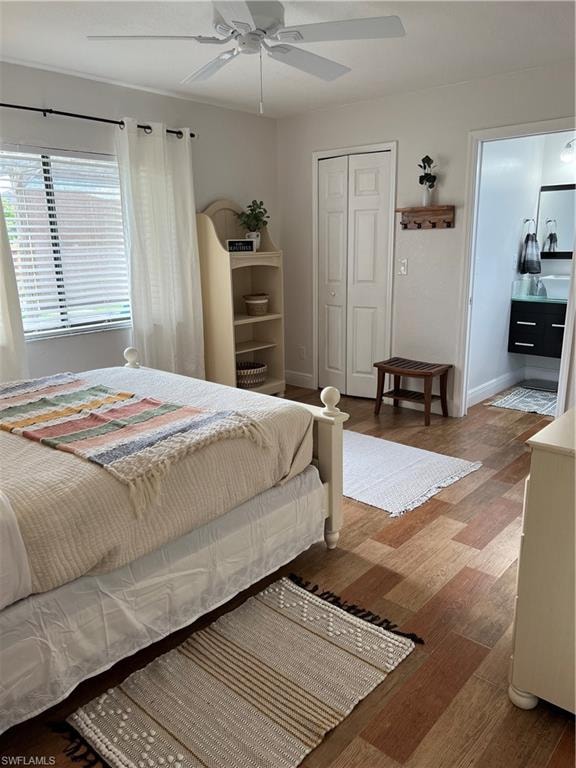 Bedroom with wood finished floors, a ceiling fan, and a closet