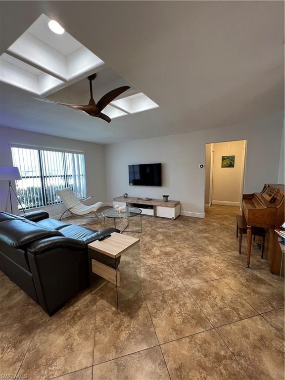 Living area featuring a ceiling fan and a skylight